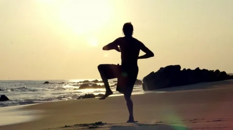 Caucasian man practicing  tai chi on the beach at sunset Stock Footage 61955762