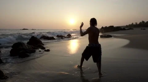 Caucasian man practicing  tai chi on the beach at sunset Video stock 61956002
