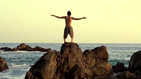 Caucasian man practicing  tai chi on the rocks in front the pacific ocean Stock Footage 61956243