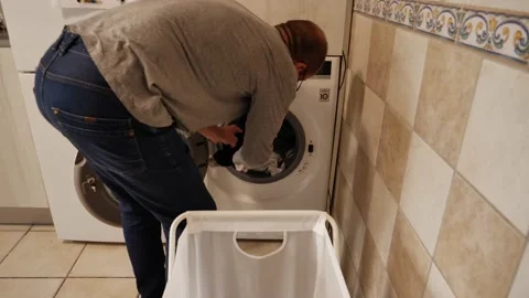 Caucasian man pulling clothes out of the washing machine. Stock Footage 156694963