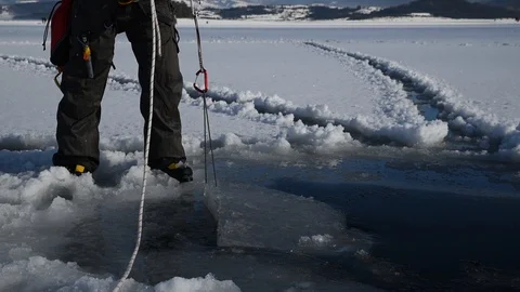Caucasian man pulling cut piece ice from the frozen lake Stock Footage 102368793