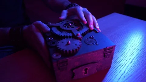 Caucasian man puts a black box on the table with gears on the cover. Puzzle Stock Footage 111699720