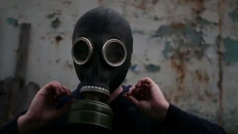 Caucasian man puts on gas mask to protect himself before apocalypse Stock Footage 197335053