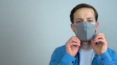 Caucasian man puts on a medical mask so as not to infect people with the virus Stock Footage