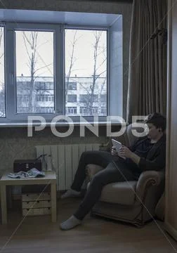 Caucasian Man Reading Digital Tablet In Living Room