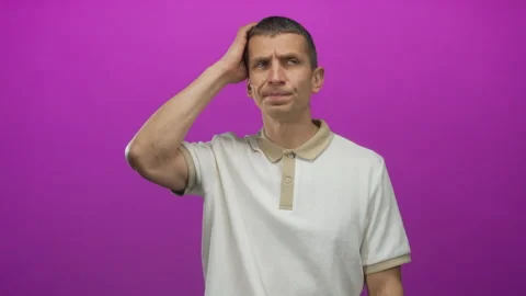 Caucasian man scratching head in confusion against vibrant pink background,.. 스톡 동영상 314244706