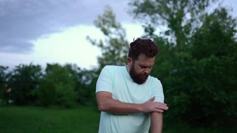 Caucasian man scratching insect bite on arm outdoors in summer park Stock Footage 295944820