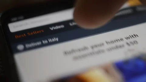 Caucasian man scroll amazon shopping app on the iphone screen display. Video stock 236455861