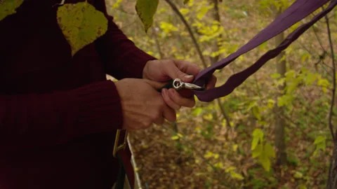 Caucasian man sets slackline between trees in the autumn forest. 스톡 동영상 142127254
