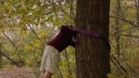 Caucasian man sets slackline between trees in the autumn forest. 스톡 동영상 142127391