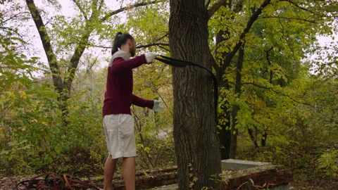 Caucasian man sets slackline between trees in the autumn forest. 스톡 동영상 142131750
