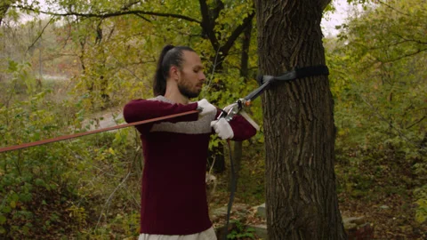 Caucasian man sets slackline between trees in the autumn forest. 스톡 동영상 142253245