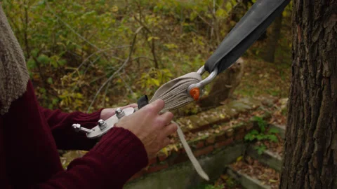 Caucasian man sets slackline between trees in the autumn forest. 스톡 동영상 142253370