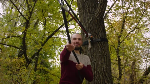Caucasian man sets slackline between trees in the autumn forest. 스톡 동영상 142270200