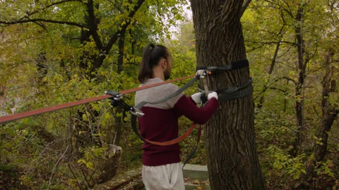 Caucasian man sets slackline between trees in the autumn forest. 스톡 동영상 142270854
