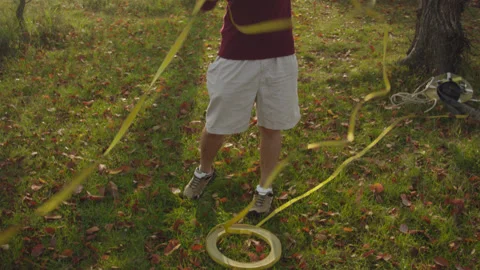 Caucasian man sets slackline between trees in the autumn forest. Stock-Footage 142302077