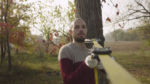Caucasian man sets slackline between trees in the autumn forest. Stock-Footage 142312622