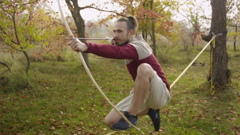Caucasian man sets slackline between trees in the autumn forest. Stock-Footage 142455521