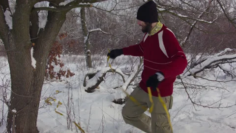 Caucasian man sets slackline between trees in the winter forest. 스톡 동영상 146914906
