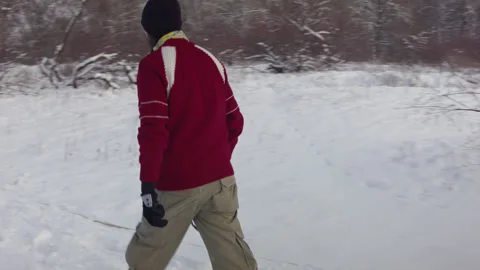 Caucasian man sets slackline between trees in the winter forest. 스톡 동영상 146960637