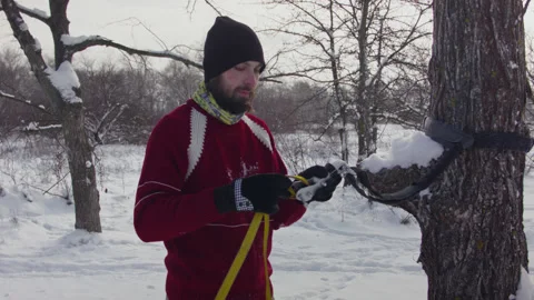 Caucasian man sets slackline between trees in the winter forest. 스톡 동영상 146964283