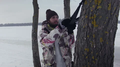 Caucasian man sets slackline between trees in the winter forest. 스톡 동영상 148085518