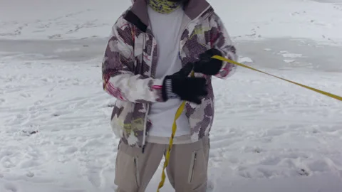 Caucasian man sets slackline between trees in the winter forest. 스톡 동영상 148095693