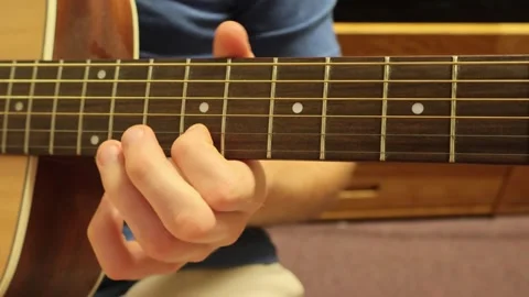 Caucasian man sitting down playing guitar fingerstyle Stock Footage 279909200