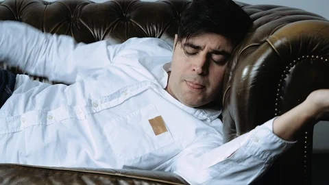 Caucasian Man Sleeping on Leather Couch Stock Footage 120414175