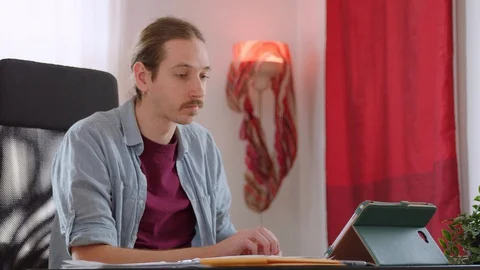 A caucasian man stands up to stretch while working from home - slow motion Stock Footage 129958523