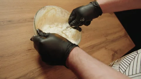 Caucasian man stirs mixture with spoon and gloved hands Video stock 330536583