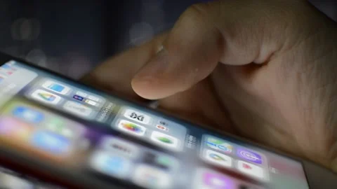 Caucasian man swipe iphone screen display in the night city blur background. Stock Footage 236379755