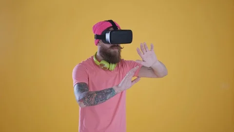 Caucasian man touch something using modern 3D vr glasses ,yellow background Stock Footage 127622382