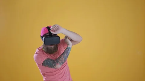 Caucasian man touch something using modern 3D vr glasses ,yellow background Stock Footage 127622485