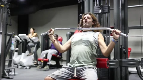 Caucasian man training on lat pull down machine in gym Caucasian man doing 스톡 동영상 239307689