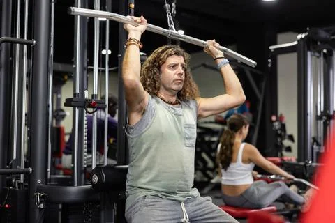 Caucasian man training on lat pull down machine in gym Stock Photos