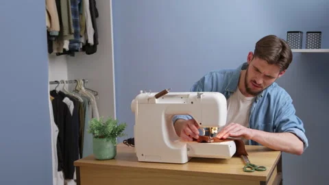 Caucasian man upset while sewing at home 스톡 동영상 244797773