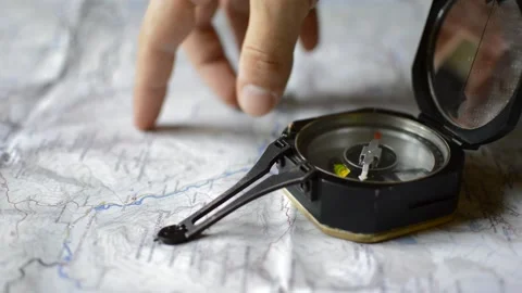 Caucasian man use a compass and a map for programming a travel Vídeo Stock 200458183