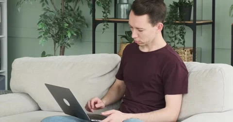 Caucasian Man Using Laptop While Sitting on Sofa Stock Footage 248532577