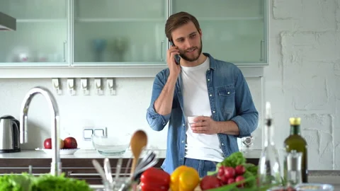 Caucasian man using smartphone and talking in kitchen at home Stock Footage 159552152