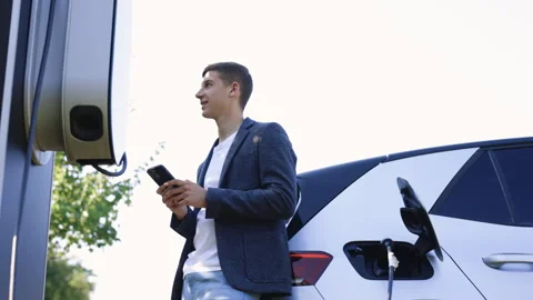Caucasian man using smartphone and waiting power supply connect to electric Video stock 249885952