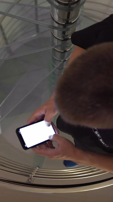 Caucasian man using smartphone and going up stairs home. Glass staircase Stock Footage 320561095