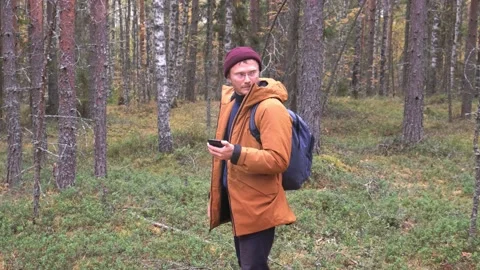 Caucasian man using smartphone to find his location in the forest. Traveler Vídeos de archivo 164218151