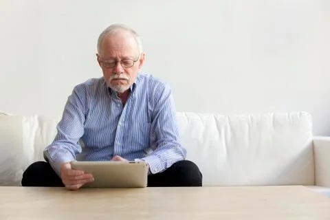 Caucasian man using tablet computer on sofa Stock Photos