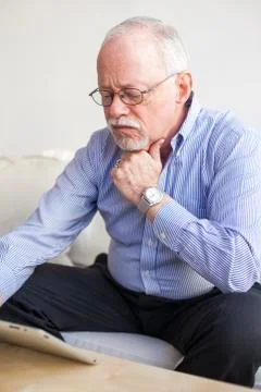 Caucasian man using tablet computer on sofa 스톡 사진