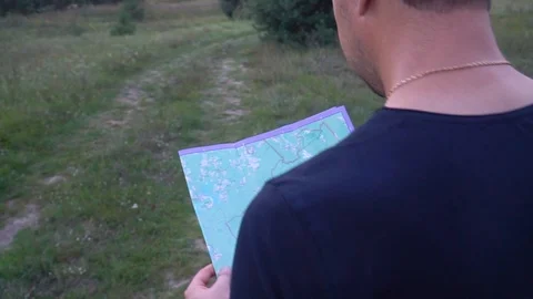 Caucasian man walking with map through forest Stock Footage 118464236