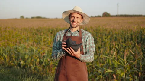 Caucasian man in work clothes looking at camera and sorting bean bags in hands. Stock Footage 317980872