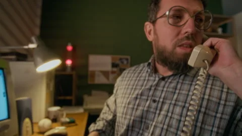Caucasian Man Working on 90s Computer at Home and Talking on Telephone Stock Footage 327231540