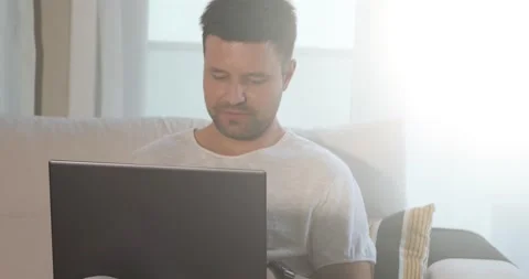 Caucasian man working with laptop on sofa in living room. Видео 160920688