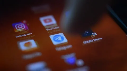 Caucasian man's hand open telegram icon app on his phone 스톡 동영상 197288330